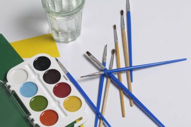 Suluboya ve beyaz bir yüzeye fırça. Sonraki cam su ve kağıt için. Yaratıcılık için konular.