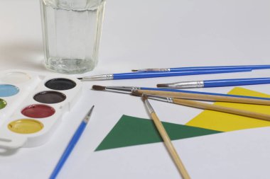 Suluboya ve beyaz bir yüzeye fırça. Sonraki cam su ve kağıt için. Yaratıcılık için konular.