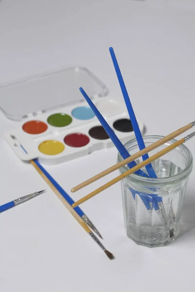 水彩絵の具と白い表面にブラシ 水のための次のガラス 創造性のための科目 — ストック写真