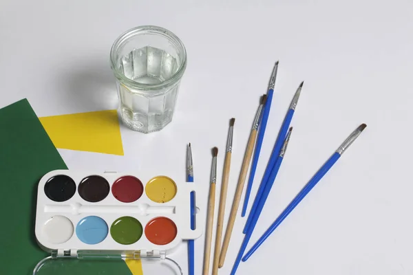 Aquarellen Borstels Een Witte Ondergrond Volgende Glas Voor Water Papieren — Stockfoto