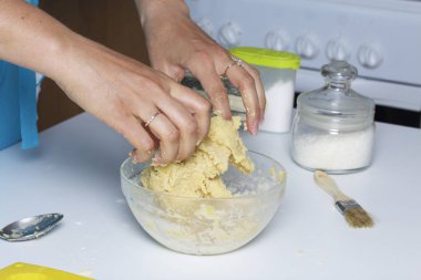 Kadın hamur cam kap içinde kneads.