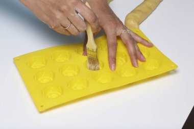 Bir kadın bir silikon yemek pişirme yağlar. Bu fırça kullanarak.