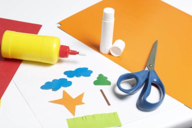 Aplike dersler. Gerekli eşyaları: tutkal, renkli kağıt, makas yalan tablo beyaz yüzeyinde. Çeşitli öğeleri kes.