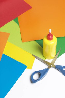 Aplike dersler. Gerekli eşyaları: tutkal, renkli kağıt, makas yalan tablo beyaz yüzeyinde.