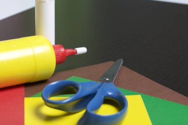 Aplike dersler. Gerekli eşyaları: tutkal, renkli kağıt, makas yalan tablo karanlık yüzeyinde.