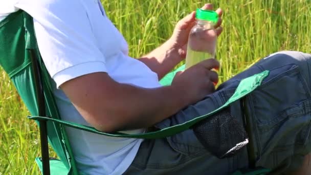 Homem Senta Numa Cadeira Piquenique Num Prado Iluminado Ele Descansa — Vídeo de Stock
