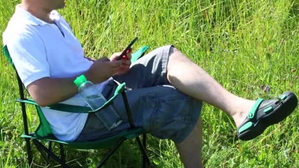 Bir Adam Bir Işıklı Çayır Piknik Sandalyeye Oturur Istirahat Bir — Stok video