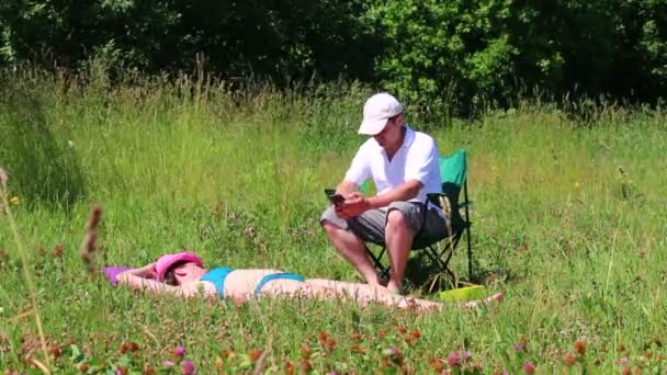 Girl Swimsuit Sunbathing Lawn Next Her Picnic Chair Man Sits — Stock Video
