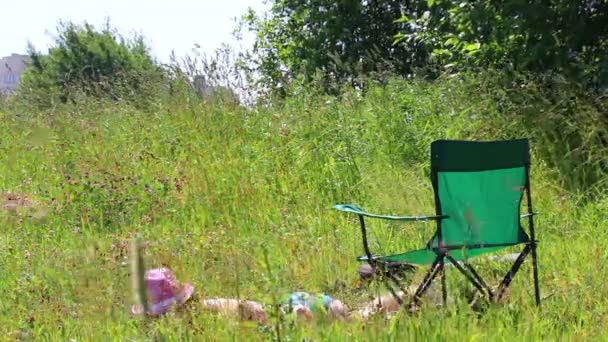 水着姿の少女は 芝生の上日光浴です ピクニック椅子に彼女の隣に — ストック動画