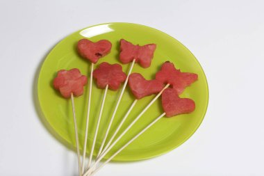 Karpuz hamuru parçalarını bir damga ile kesilir. Onlar farklı biçimleri verilmiştir. Yaylı şiş piknik için üzerinde.