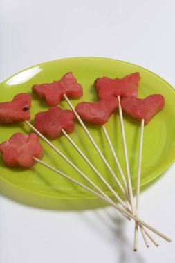 Karpuz hamuru parçalarını bir damga ile kesilir. Onlar farklı biçimleri verilmiştir. Yaylı şiş piknik için üzerinde.