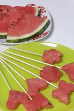 Karpuz hamuru parçalarını bir damga ile kesilir. Onlar farklı biçimleri verilmiştir. Yaylı piknik için şiş üzerinde. Kalenin yanındaki karpuz parçaları nelerdir.