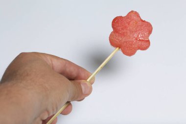 Karpuz hamuru parçalarını bir damga ile kesilir. Onlar farklı biçimleri verilmiştir. Yaylı piknik için şiş üzerinde. Adam bir şiş elinde tutuyor.