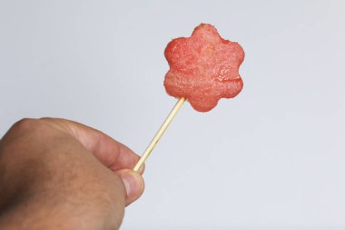 Karpuz hamuru parçalarını bir damga ile kesilir. Onlar farklı biçimleri verilmiştir. Yaylı piknik için şiş üzerinde. Adam bir şiş elinde tutuyor.