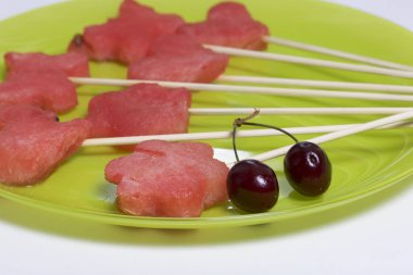 Karpuz hamuru parçalarını bir damga ile kesilir. Onlar farklı biçimleri verilmiştir. Yaylı piknik için şiş üzerinde. Orada birkaç meyveleri tatlı kiraz.