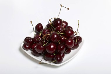 Olgun kiraz yalanlar üzerine bir daire. Beyaz bir arka plan üzerinde.