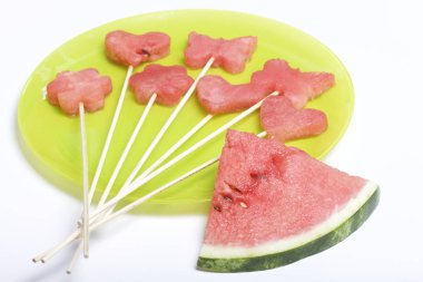 Karpuz hamuru parçalarını bir damga ile kesilir. Onlar farklı biçimleri verilmiştir. Yaylı piknik için şiş üzerinde. Kalenin yanındaki karpuz parçaları nelerdir.