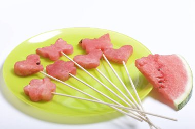 Karpuz hamuru parçalarını bir damga ile kesilir. Onlar farklı biçimleri verilmiştir. Yaylı piknik için şiş üzerinde. Kalenin yanındaki karpuz parçaları nelerdir.