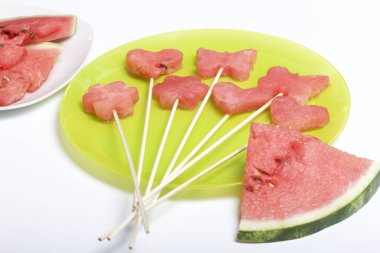 Karpuz hamuru parçalarını bir damga ile kesilir. Onlar farklı biçimleri verilmiştir. Yaylı piknik için şiş üzerinde. Kalenin yanındaki karpuz parçaları nelerdir.