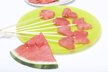 Karpuz hamuru parçalarını bir damga ile kesilir. Onlar farklı biçimleri verilmiştir. Yaylı piknik için şiş üzerinde. Kalenin yanındaki karpuz parçaları nelerdir.