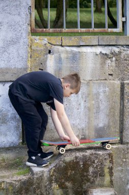 Bir kaykay ile bir genç. Bir paten elinde tutan.