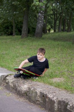 Bir kaykay ile bir genç. Bir paten elinde tutan.