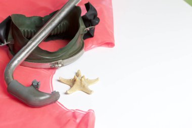 Sahilde tatile. Hava olmadan bir yüzme daire. Beyaz zemin üzerinde bir tüp ve su altında yüzme için maske. Yakın deniz yıldızı olduğunu.