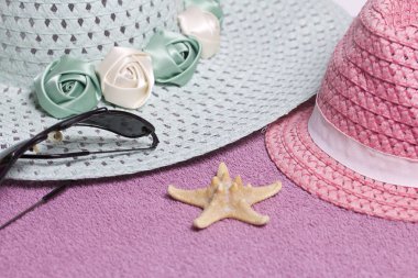 Sahilde tatile. Güneş ve güneş gözlüğü koruma için şapka. Plaj havlusu arka planı.