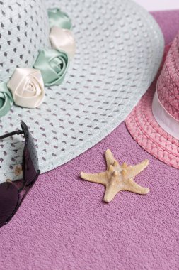 Sahilde tatile. Güneş ve güneş gözlüğü koruma için şapka. Plaj havlusu arka planı.