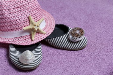 Sahilde tatile. Güneşten korunması için şapka. Plaj Spor Ayakkabı, deniz yıldızı. Plaj havlusu arka planı.