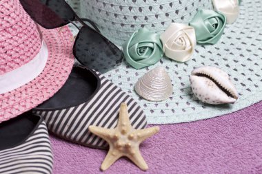 Sahilde tatile. Güneş ve güneş gözlüğü koruma için şapka. Plaj Spor Ayakkabı, deniz yıldızı. Plaj havlusu arka planı.