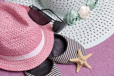 Sahilde tatile. Güneş ve güneş gözlüğü koruma için şapka. Plaj Spor Ayakkabı, deniz yıldızı. Plaj havlusu arka planı.