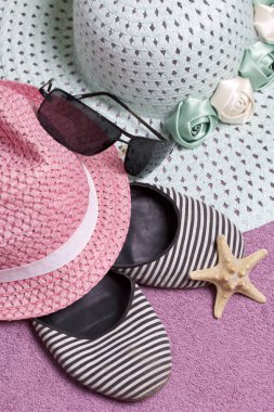 Sahilde tatile. Güneş ve güneş gözlüğü koruma için şapka. Plaj Spor Ayakkabı, deniz yıldızı. Plaj havlusu arka planı.