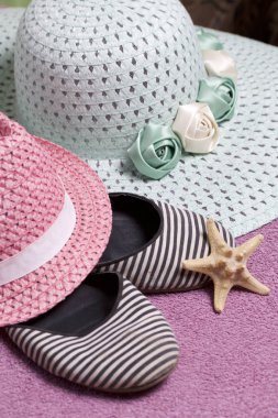 Sahilde tatile. Güneşten korunması için şapka. Plaj Spor Ayakkabı, deniz yıldızı. Plaj havlusu arka planı.