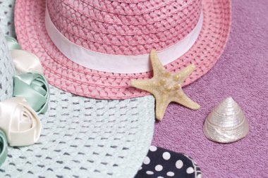 Sahilde tatile. Güneşten korunması için şapka. Plaj Spor Ayakkabı, deniz kabuklarını. Plaj havlusu arka planı.