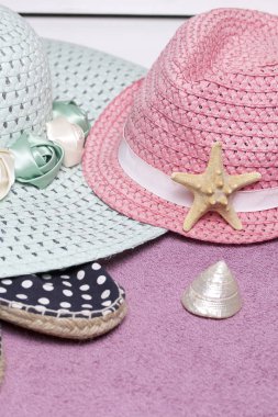 Sahilde tatile. Güneşten korunması için şapka. Plaj Spor Ayakkabı, deniz kabuklarını. Plaj havlusu arka planı.