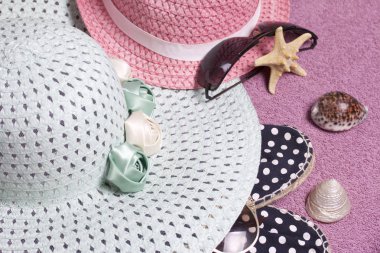 Sahilde tatile. Güneş ve güneş gözlüğü koruma için şapka. Plaj spor ayakkabıları. Deniz yıldızı ve deniz kabuklarını. Plaj havlusu arka planı.