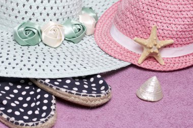 Sahilde tatile. Güneşten korunması için şapka. Plaj Spor Ayakkabı, deniz kabuklarını. Plaj havlusu arka planı.