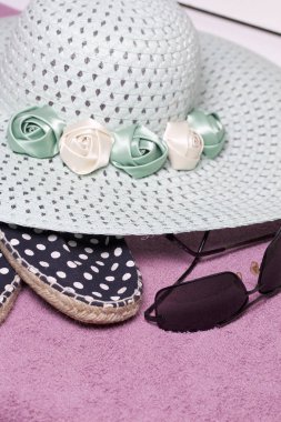 Sahilde tatile. Güneş ve güneş gözlüğü koruma için şapka. Plaj spor ayakkabıları. Plaj havlusu arka planı.