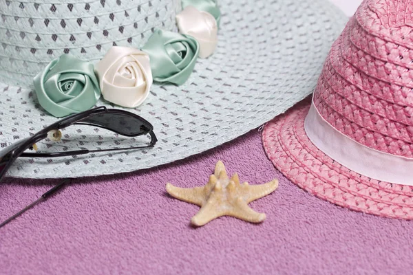 Sahilde tatile. Güneş ve güneş gözlüğü koruma için şapka. Plaj havlusu arka planı.