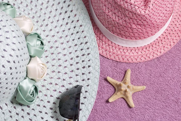 Sahilde tatile. Güneş ve güneş gözlüğü koruma için şapka. Plaj havlusu arka planı.