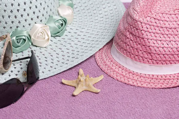 Sahilde tatile. Güneş ve güneş gözlüğü koruma için şapka. Plaj havlusu arka planı.