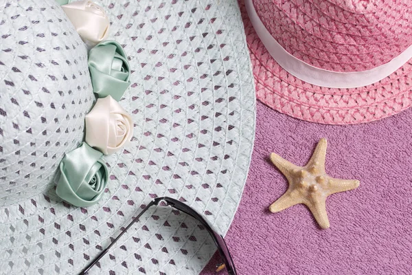 Sahilde tatile. Güneş ve güneş gözlüğü koruma için şapka. Plaj havlusu arka planı.