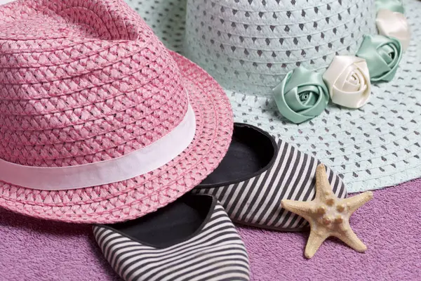 Sahilde tatile. Güneşten korunması için şapka. Plaj Spor Ayakkabı, deniz yıldızı. Plaj havlusu arka planı.