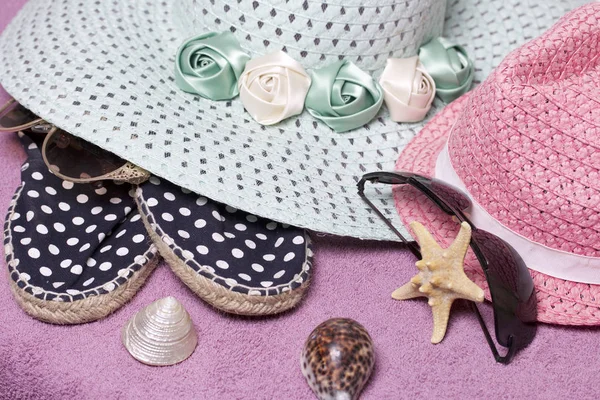 Sahilde tatile. Güneş ve güneş gözlüğü koruma için şapka. Plaj spor ayakkabıları. Deniz yıldızı ve deniz kabuklarını. Plaj havlusu arka planı.