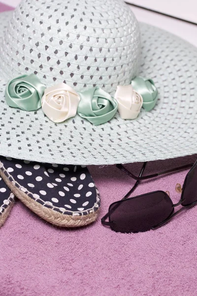 Sahilde tatile. Güneş ve güneş gözlüğü koruma için şapka. Plaj spor ayakkabıları. Plaj havlusu arka planı.