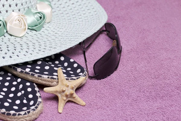 Sahilde tatile. Güneş ve güneş gözlüğü koruma için şapka. Plaj spor ayakkabıları. Deniz yıldızı. Plaj havlusu arka planı.