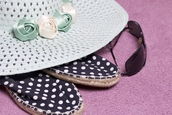 Sahilde tatile. Güneş ve güneş gözlüğü koruma için şapka. Plaj spor ayakkabıları. Plaj havlusu arka planı.