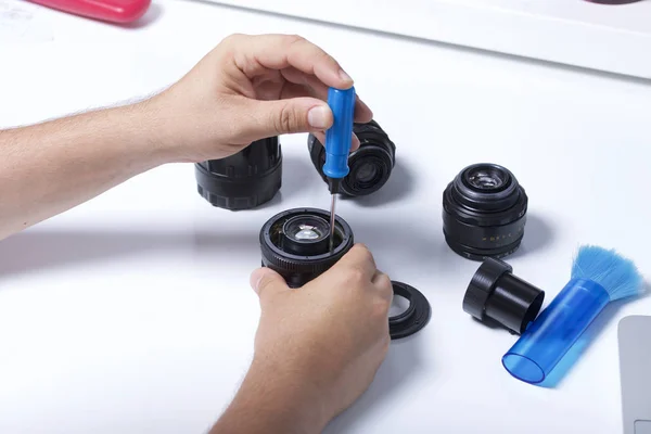 Man Dismantles Lens Uses Screwdriver Repair Maintenance Lenses Nearby Table — Stock Photo, Image