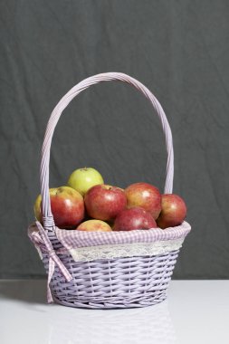 Elma sonbahar hasat. Bir hasır asma sepetten elma. Gri bir arka plan üzerinde.